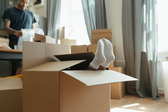 brown-cardboard-box-with-a-small-childs-feet-sticking-out-wearing-white-socks