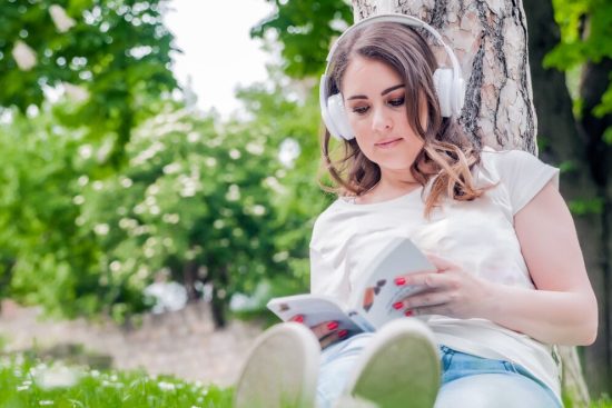 close-up-young-relaxed-woman-reading-listening-music-headphones-outside-spring-day-freetime-concept-with-beautiful-female-relaxing-outdoors-with-music-books-coffee_1391-670