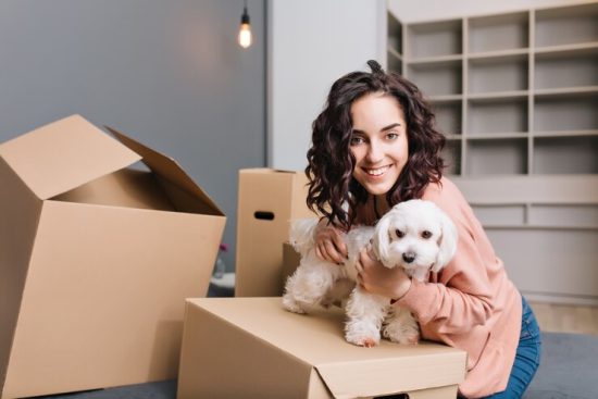 moving-new-apartment-young-pretty-woman-with-little-dog-chilling-bed-surround-carton-boxes-with-pet-smiling-expressing-positivity_197531-2601