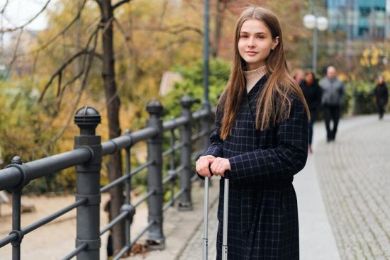 pretty-smiling-girl-coat-with-suitcase-happily-looking-camera-city-street_574295-2541