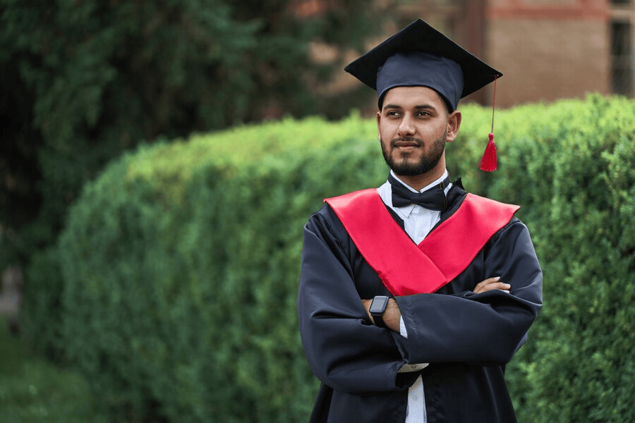 serious-indian-graduate-graduation-robe-with-crossed-arms-looking-forward_496169-1338