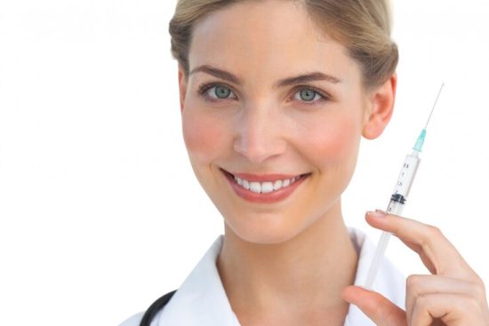 smiling-nurse-holding-syringe_13339-1341