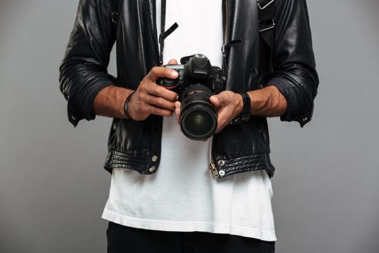 stylish-afro-american-guy-holding-digital-camera_171337-1353