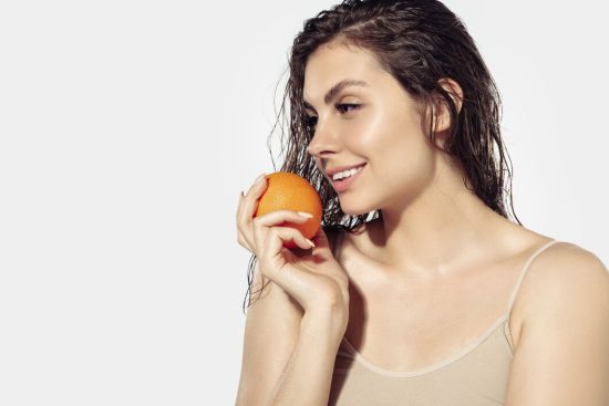 vitamins-beautiful-smiling-young-woman-with-orange-near-face-white-wall-concept-cosmetics-makeup-natural-eco-treatment-skin-care-shiny-healthy-skin-fashion-healthcare_155003-40882